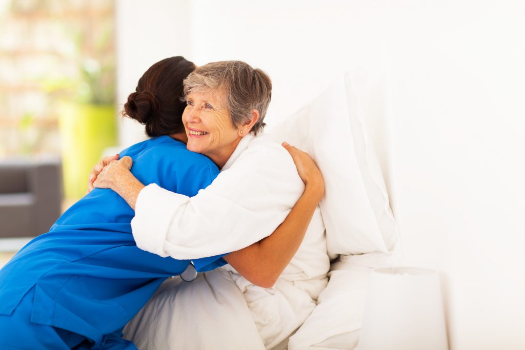 happy elderly woman hugging respite care Brisbane nurse
