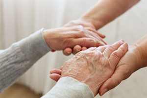close up photo of an aged persons hands in a carer's hands