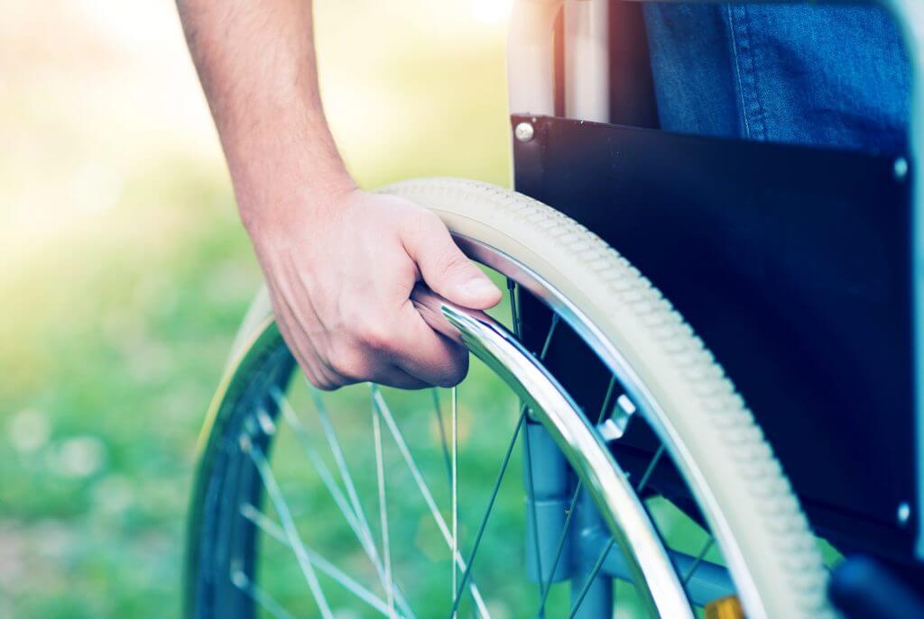 disabled man's hand on wheelchair wheel